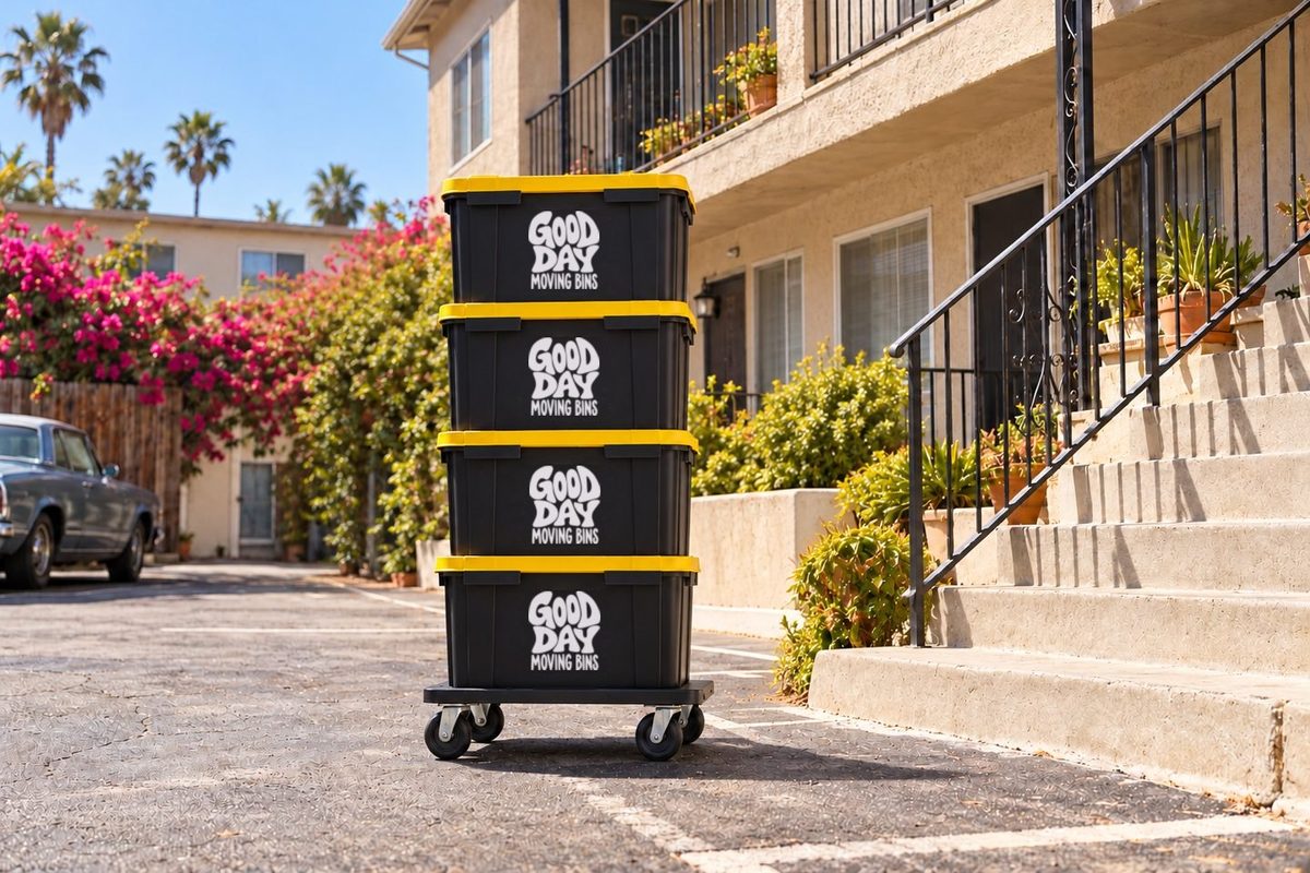 Four Good Day moving bins stacked on a dolly in an apartment parking lot